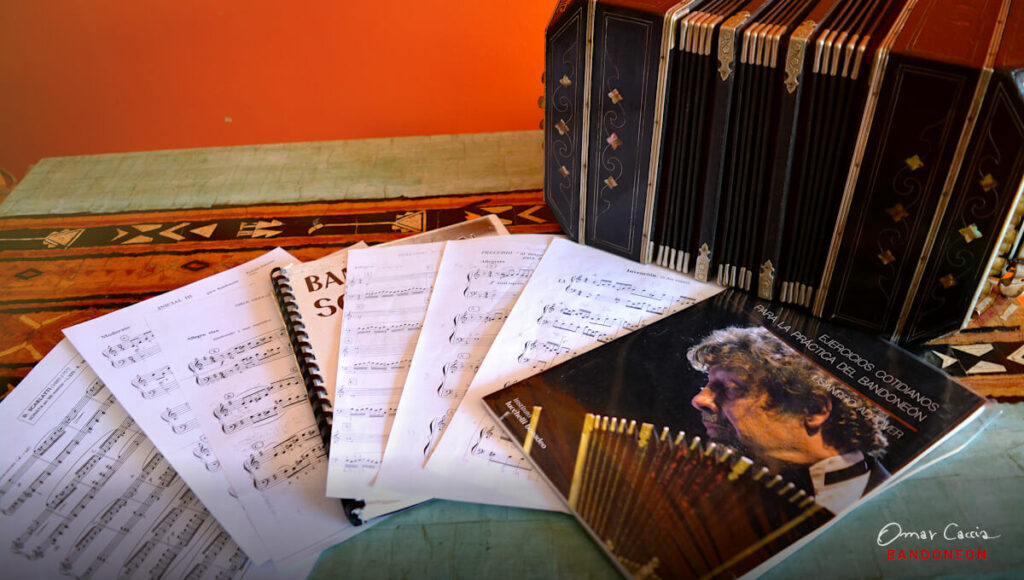 Scores for bandoneon on a table and a bandoneon next to them.