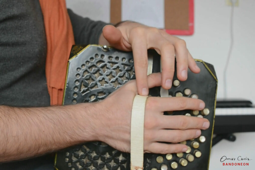 The point where the strap lies on the hand is the center point on the bandoneon and the center of the rotation for the hand